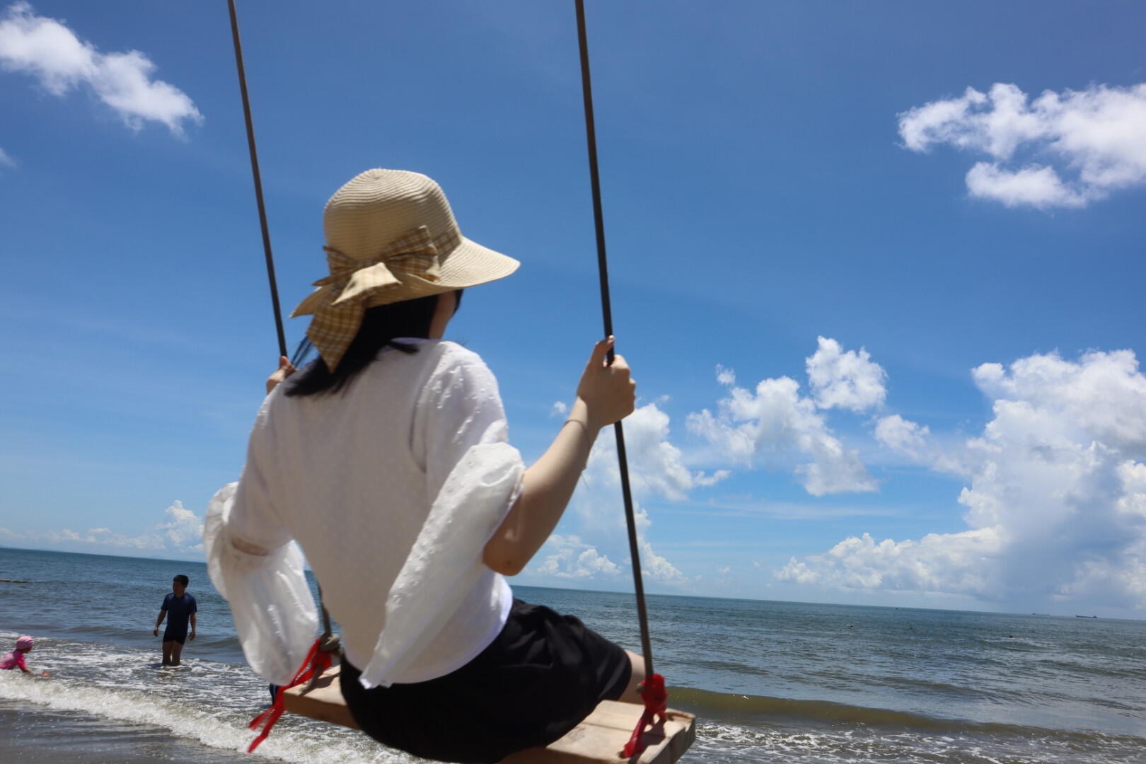 海边秋千上无忧无虑的少女